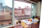 Bright sun room (covered terrace) overlooking rooftops, church towers, neighbors’ gardens and Piazza Sant’Anastasio